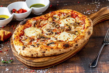Cheese and mushroom pizza with toppings on the cutting board