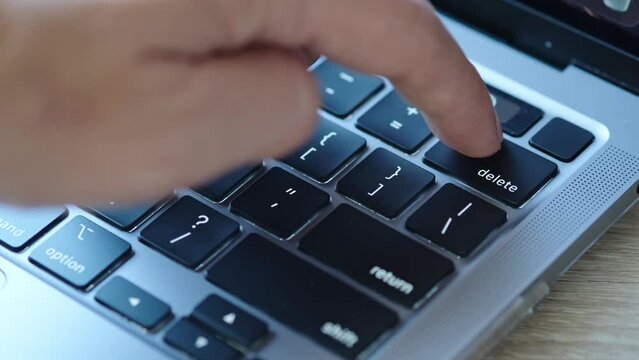 	
Finger of the computer user, he presses the delete button on the computer keyboard.	
