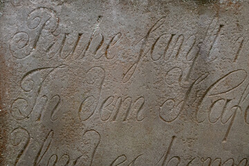 Inscription on the stone of an old tombstone - Rest in peace in German