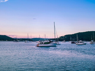 Beautiful scenery at sunset in the small resort town of Killcare with boats on the water in the foreground on the Central Coast, NSW, Australia.