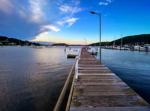 Seascape perspective at sunset in the small resort town of Killcare with the pier and marina in the foreground on the Central Coast, NSW, Australia.