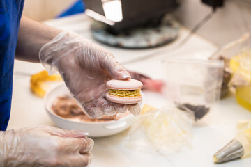 confectioner collects halves of macarons cookies. close-up. home bakery concept.