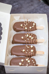 marshmallows in chocolate on a stick on the kitchen table. home bakery concept.