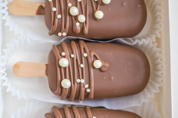 marshmallows in chocolate on a stick on the kitchen table. home bakery concept.