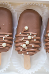 marshmallows in chocolate on a stick on the kitchen table. home bakery concept.