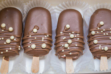 marshmallows in chocolate on a stick on the kitchen table. home bakery concept.