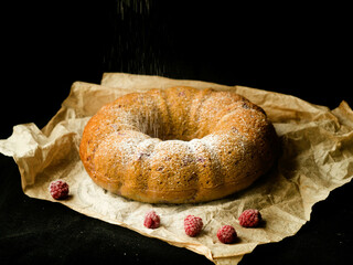 Vanilla bundt cake with fresh raspberries on a black table. vegetarian, lean, dairy and egg free. Selective focus. Close up