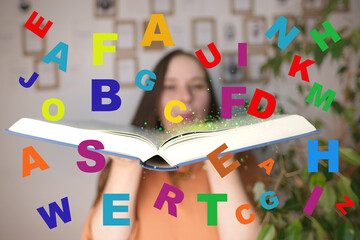 closeup scattering of multi-colored different letters against background of young girl with book in...