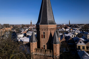 Closeup of Drogenapstoren cants in medieval Hanseatic Dutch tower town Zutphen in the Netherlands with historic heritage buildings covered in snow in the background