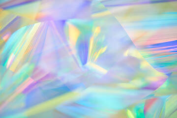 Close-up of ethereal pastel neon mint, blue, purple, yellow holographic metallic foil background....
