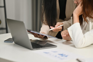 Business people looking at laptop brainstorming, collaborating on project development in corporate office