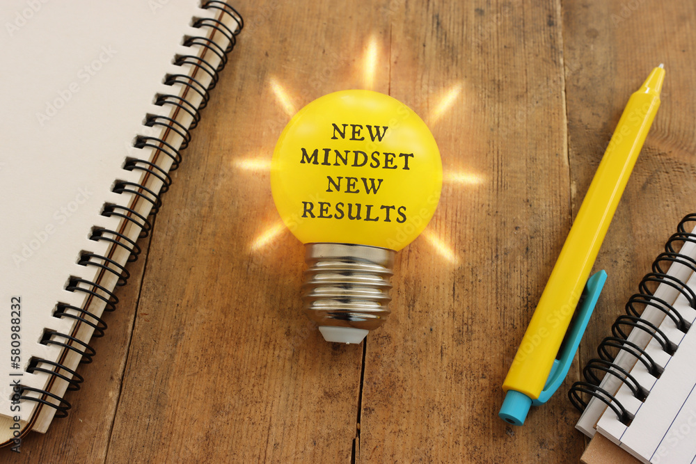 Poster light bulb with the text new mindset in on wooden table