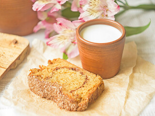 Homemade sponge cinnamon cake on white table, soft and moist dessert with milk. Homemade bakery concept for background, copy space, selective focus. Pound butter fluffy pie, white background.