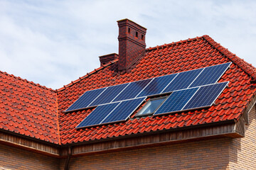 Modern solar panels on a red tiled roof.