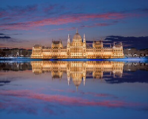 Obraz premium view on Parliament building in Budapest with fantastic perfect sky and reflection in water at dusk. calm Danube river. Popular Travel destinations. creative image used as background.