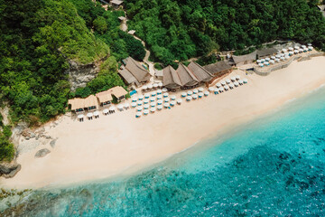 Aerial view of ocean and luxury beach resort with umbrellas in Bali