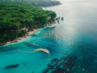 Naklejka premium Aerial view of blue ocean with scenic coastline and plastic pollution in water on Bali