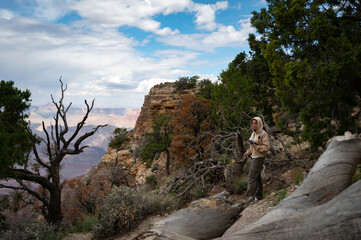 Fototapeta na wymiar Young girl with sweatshirt and hoodie taking pictures in the nature of the Grand Canyon