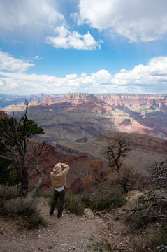 Young girl with sweatshirt and hoodie taking pictures in the nature of the Grand Canyon