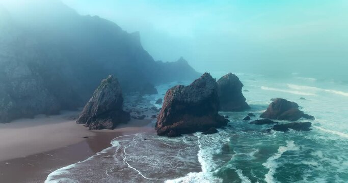 Aerial view pf the most western point of the European continent - Cabo da Roca, Portugal. Drone flies over the Atlantic ocean coast, rocky formations and the beach called Praia da Ursa.