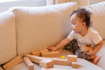 Asian boy baby toddler playing with wooden blocks