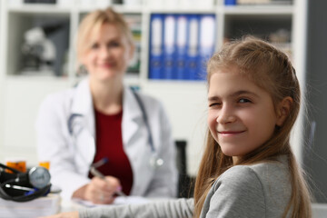 Portrait of child girl winks at camera in doctor office