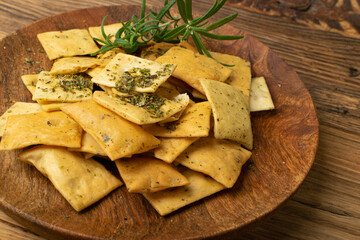Pita Chips Pile on Wood Plate, Small Wheat Tortillas, Crunchy Flat Bread, Spicy Mediterranean Wheat Snack