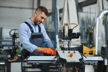Male factory mechanics or Engineer in safety uniforms are working on metal drilling machines in...