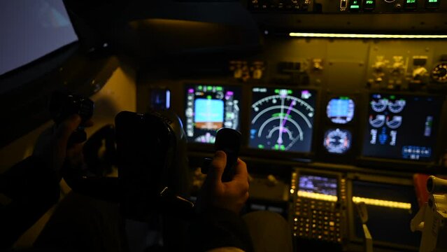 A man is studying to be a pilot in a flight simulator. Close-up of male hands navigating an aircraft.