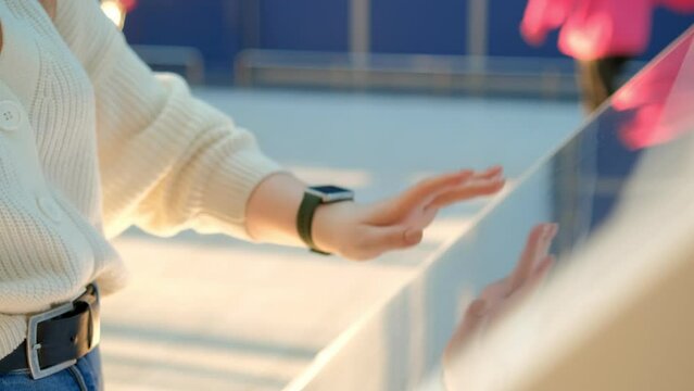 Beautiful young woman looking for information and location of shopping place on digital touch screen in shopping mall 4K