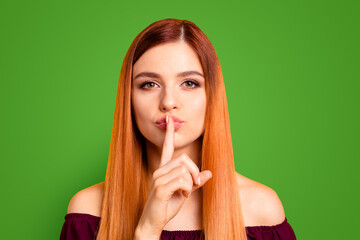 Portrait of red straight-haired attractive cute nice funny young girl, showing shh silence with...