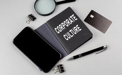 CORPORATE CULTURE text written on black notebook with smartphone, magnifier and credit card