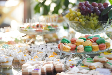 Sweets candy bar. Close up sweets photography with diferent color macarons French cuisine desert dishes at a party.