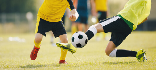 Slide Tackle in Soccer Match. Two Young Soccer Players in a Duel Compete For Ball. Teenage Players...