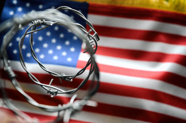 Barbed wire and United States of America flag , immigration stock photo.