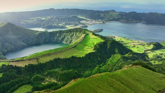 Flying over Lagoa das Sete Cidades lake in sunny day. Sao Miguel Island, Azores, Portugal. Lakes in the craters of extinct volcanoes surrounded by green vegetation