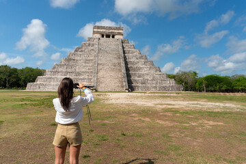 Tourist girl in front of the background of the Kukulcan pyramid in the Mexican city of Chichen...