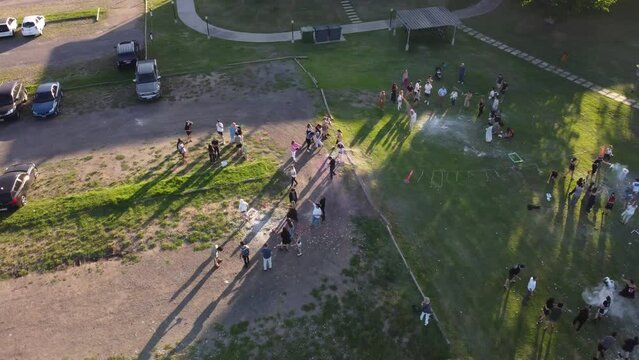 Aerial orbiting shot of classic school graduation celebration in Argentina with family and friends