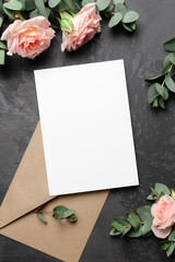 Invitation or greeting card mockup with envelope and roses flowers on black background