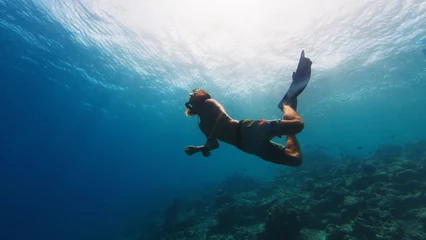 Fotobehang Man freedives in the sea © Dudarev Mikhail