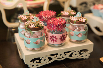 glass jar decorated with flowers on a white metal stand