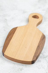 Empty wooden cutting board above grey marble background