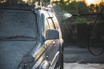 Treatment with white cleaning foam for washing a car from a high-pressure hose at a self-service...