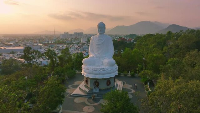 Drone view Kim Than Phat To Buddha statue on mountain by Long Son pagoda, in sunset - Nha Trang, Khanh Hoa province, central Vietnam