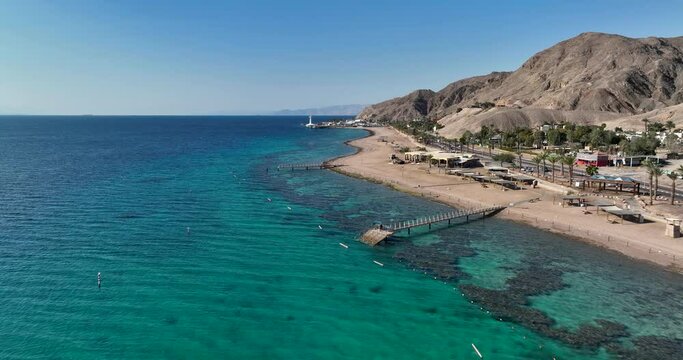 Aerial footage of a pier made of wood near Eilat Coral Beach Nature Reserve. Filmed in C4K Apple ProRes 422 HQ