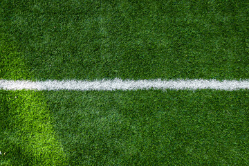 White stripe markings on the green grass of the soccer field, copy space background. © Roman