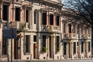 Old residential buildings in Barcelona neighborhood, Spain. Empty European street on a sunny weekend morning. Relaxed and calm city living concept.