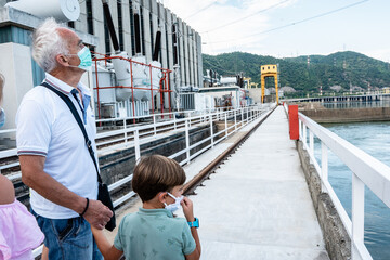 Grandfather showing his grandchildren a hydroelectrical power station