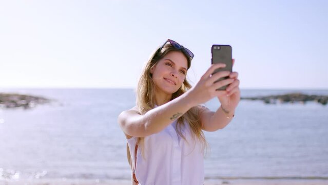 Woman, beach and selfie with phone for travel blog, social media and summer vacation, holiday and relax in sunshine. Happy tourist, girl and taking photograph on smartphone at sea, ocean and freedom