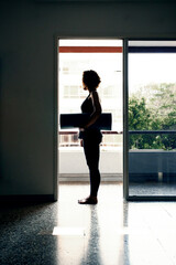 Young woman with yoga mat preparing to do yoga practice practicing yoga in your interior home ,backlighting silhouette